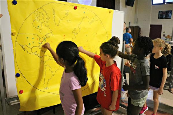 Students leave their fingerprint on a map of the world. 